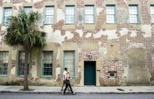 Two people walking on a charleston street near an old building. Charleston digital marketing